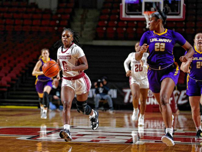 UMass guard Alexsia Rose (0) breaks down the court defended by UAlbany’s Deja Evans (22) earlier this season at the Mullins Center in Amherst.