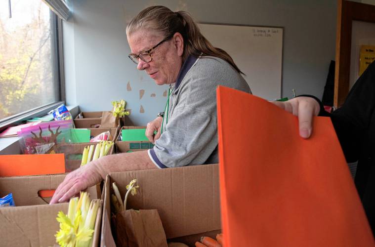 Anne Barnes, a family support worker with the Bridge Family Resource Center in Amherst, fills boxes with fresh food items, turkeys, craft activities as well as directions and recipes for 45 families for the Thanksgiving Day holiday.