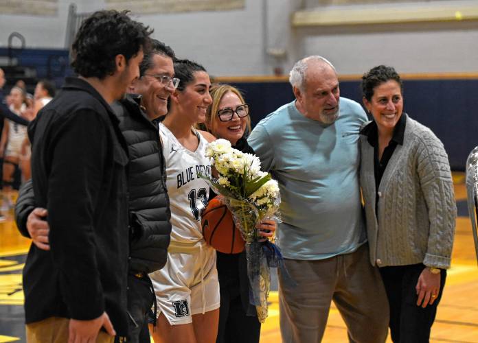 Northampton’s Ava Azzaro (center) poses with her family after scoring 1,000th point of her career against Wahconah on Monday night in Northampton.