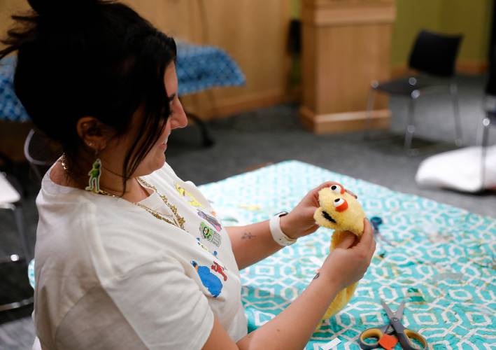 Samantha Morin works on a puppet creation during a deluxe sock puppet class by Homeslice Puppetry on Thursday night at the South Hadley Public Library. 