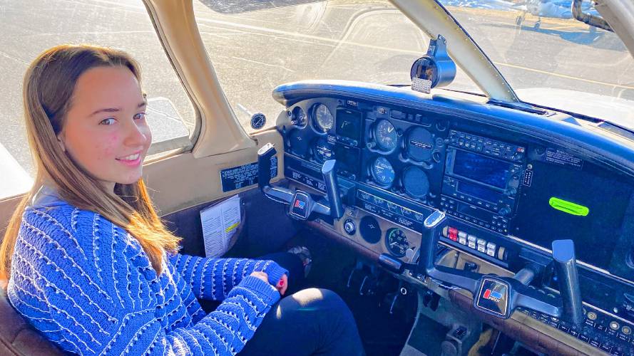 Brook Wolcott, 17, sits inside one of the small planes at Northampton Airport. Wolcott obtained her private pilot’s license in January, enabling her to fly to any civilian airport she wishes.