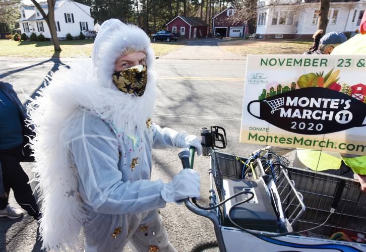 Radio personality Christopher “Monte” Belmonte, with his microphone in hand, pushes an empty shopping cart down Sugarloaf Street in South Deerfield  during the 2020 Monte’s March.