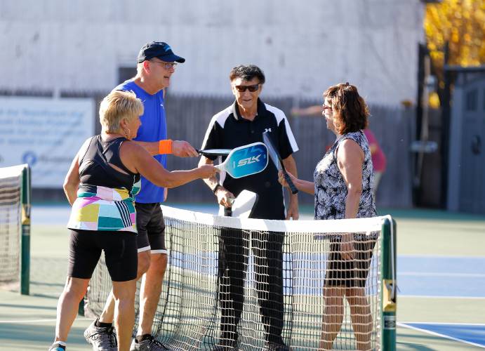 Annelis Goulet, from left, Joe Dragen, Hal Guillen and Roxanne Wood meet at the net after finishing their match in the senior division of the 3-day pickleball tournament Friday at Buttery Brook Park in South Hadley.