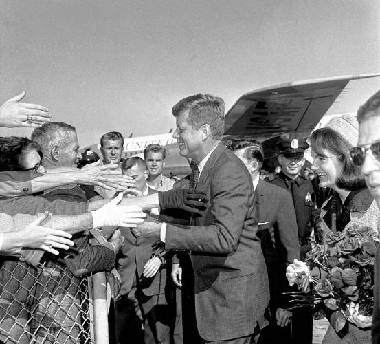 Hands reach out to greet President John F. Kennedy and first lady Jacqueline Kennedy upon their arrival at Dallas Love Field, Nov. 22, 1963. The president was shot twice and pronounced dead within an hour and a half of this photograph being taken.