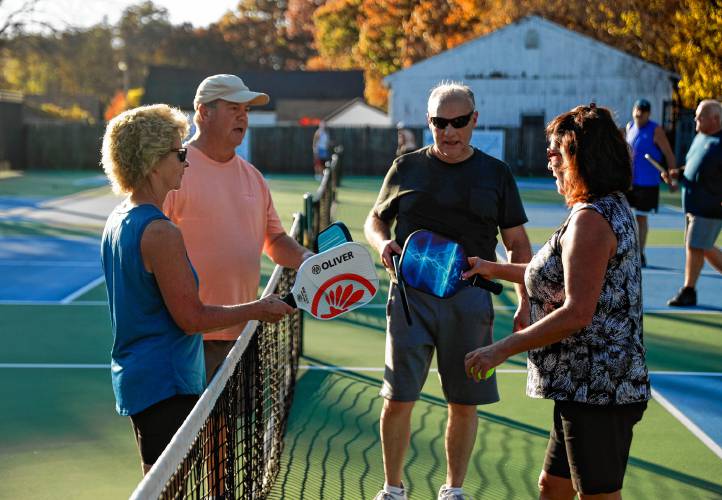Brenda McDonald, from left, Shawn Obrien, Rick Robar and Roxanne Wood meet at the net after their senior division match in a pickleball tournament at Buttery Brook Park.